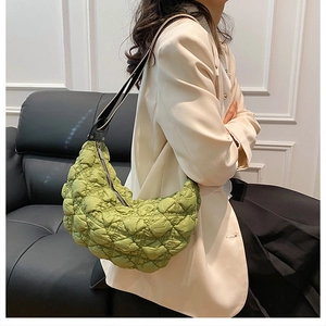 Dettaglio della borsa a mezzaluna in nylon trapuntato verde con tracolla in pelle nera