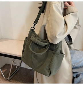 Detail view of the vintage dark green corduroy tote bag with multiple front pockets