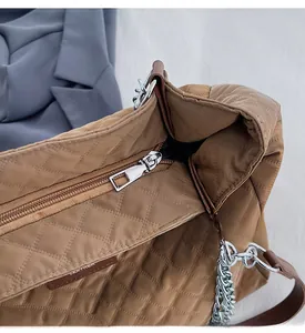 Gros plan sur le sac bandoulière en nylon matelassé avec fermeture éclair argentée