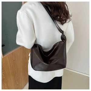 Detail view of a vintage chocolate brown PU leather hobo bag worn over the shoulder