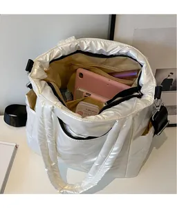 Top view of a white quilted tote bag showing its large interior capacity with gadgets