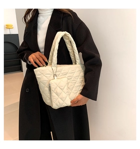 Detail shot of cream white quilted handbag set with diamond stitching and matching mini pouch