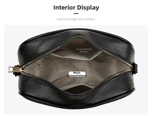 Detail view of black pebble leather camera bag interior with golden zipper and compartments