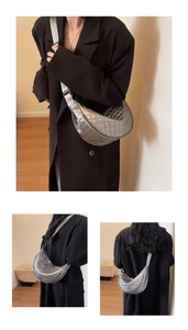 Detail of silver quilted half-moon crossbody bag with adjustable wide fabric strap