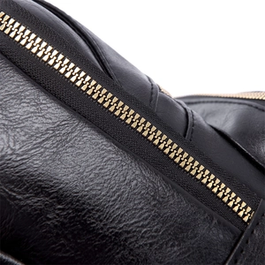 Macro detail of black pebble leather texture with high-quality golden metal zipper