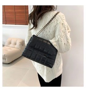 Détail du sac bandoulière noir en PU matelassé avec une élégante bandoulière dorée