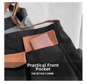 Close-up of canvas shoulder bag showing front pocket storage and durable fabric detail