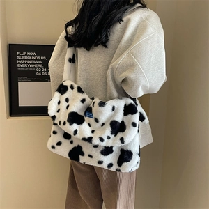 Winter plush shoulder bag with black and white cow print and soft faux fur texture