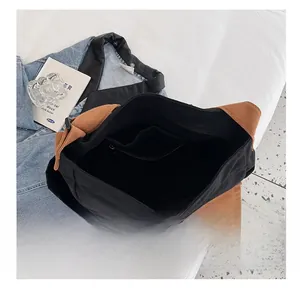 Detail view of the large canvas crossbody bag with internal zipper pocket and black lining