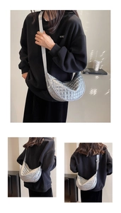 Close-up of silver metallic crescent bag featuring quilted texture and adjustable strap