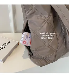 Quilted tote bag detail featuring a functional side zipper pocket for small essentials