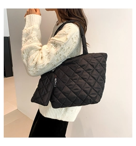 Detail of black quilted cotton tote bag and matching mini pouch for women's daily use