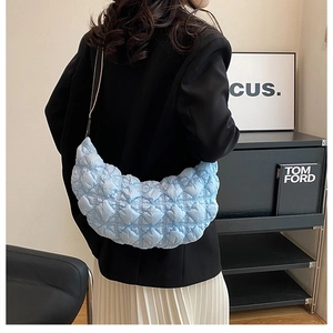 Dettaglio borsa a mezzaluna trapuntata celeste con morbida texture e motivo a rombi