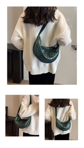 Detail of dark green quilted half-moon crossbody bag with glossy finish and strap