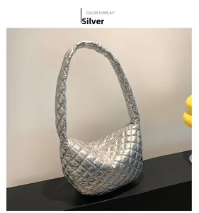 Silver quilted half-moon shoulder bag shown in a professional studio product display