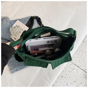 Detail view of dark green canvas shoulder bag interior showing large storage capacity