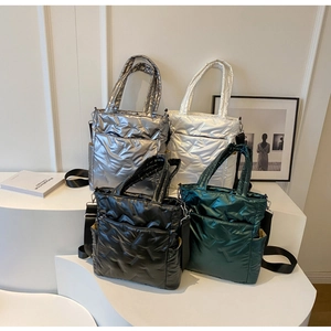 Detailed view of quilted tote bags in silver, white, black and green glossy metallic finish