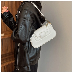 Detail view of a white PU leather shoulder bag with a square buckle on a black jacket