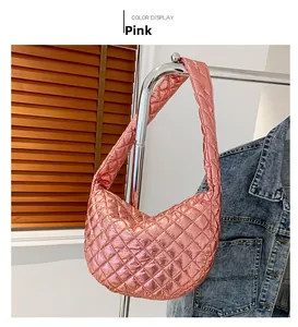 Detail of red metallic quilted hobo bag with diamond pattern on a metal hanger