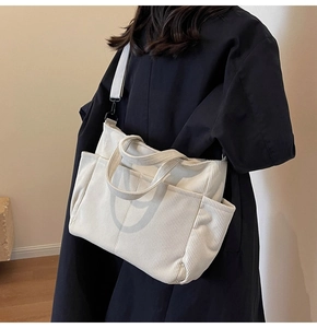 Detail view of ivory corduroy tote bag with multiple pockets and adjustable shoulder strap