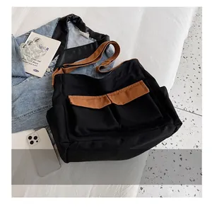 Detailed comparison showing large canvas messenger bag size next to a smartphone