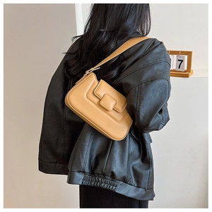 Model wearing a mustard yellow PU leather shoulder bag with an adjustable strap