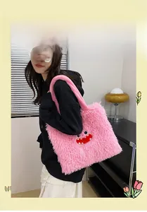 Détail du cabas en fausse fourrure rose avec broderie monstre rouge sur sac en peluche