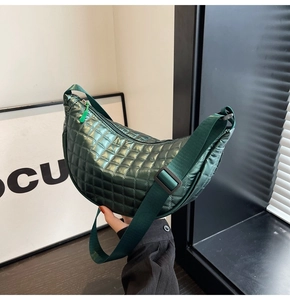Detail of green metallic quilted hobo bag featuring wide adjustable strap and zipper
