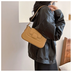 Close-up of light brown matte leather shoulder bag worn with a black leather jacket