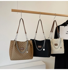 Détails rapprochés des sacs cabas en nylon matelassé en kaki, noir et blanc