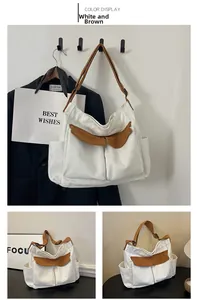 Detail view of large canvas shoulder bag in white and brown with external utility pockets