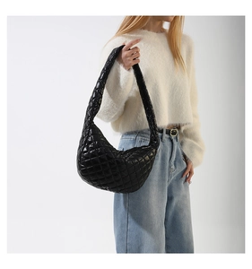 Close-up of black quilted hobo bag featuring puffy rhombic texture and crescent shape