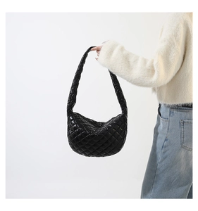 Close-up of black quilted hobo bag with glossy finish and rhombus pattern detail