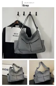 Detail view of grey multi-pocket canvas crossbody bag with dual front flap pockets