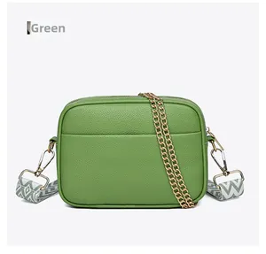 Detail of green litchi grain leather crossbody bag with chic golden chain and strap