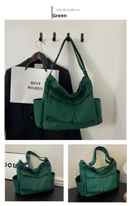 Detail of green canvas messenger bag featuring multiple utility pockets and wide strap