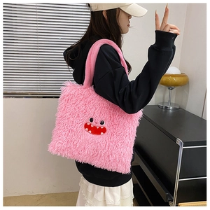 Détail du cabas en peluche rose avec texture en fausse fourrure et visage rigolo