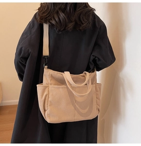 Detail of light khaki corduroy tote bag showing textured stripes and adjustable strap