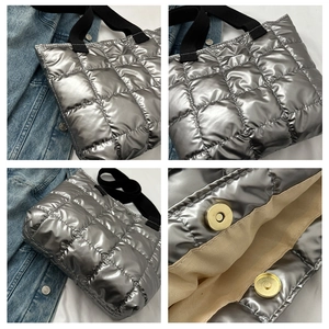 Detail of silver quilted puffer tote bag with magnetic closure and metallic fabric