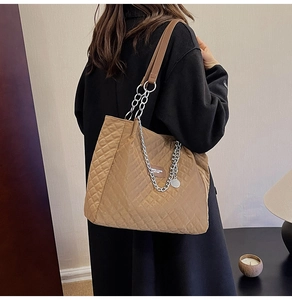 Détail du sac fourre-tout matelassé marron avec bandoulière chaîne et étiquette mode