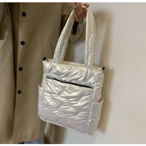 Detailed macro view showing the quilted texture and glossy finish of the white tote bag