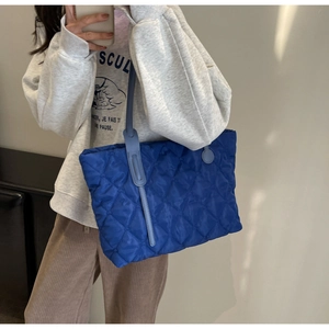 Spiegel-Selfie einer gepolsterten königsblauen gesteppten Nylon-Tasche mit Rautenmuster
