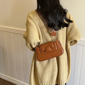 Caramel PU leather crossbody bag with geometric woven strap on casual knit sweater