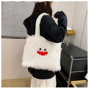 Vue détaillée du tissu en peluche blanche douce et de la broderie de monstre rouge sur le sac