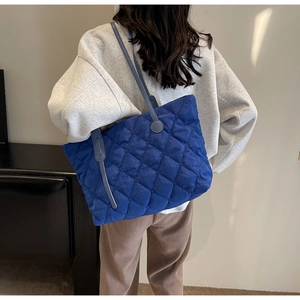 Detailansicht der gesteppten blauen Nylon-Einkaufstasche mit Rautenmuster und Lederriemen