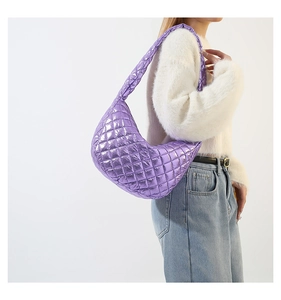Detailed close-up of purple quilted crescent moon shoulder bag with metallic finish