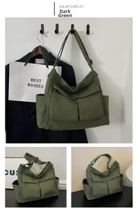 Detail view of dark green canvas crossbody bag featuring functional front flap pockets