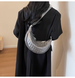 Silver metallic crescent crossbody bag with diamond quilting and adjustable strap detail