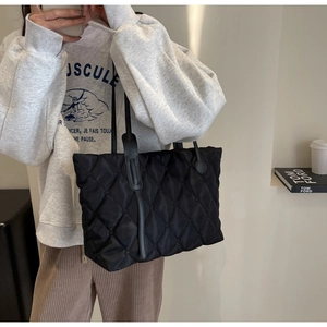 Schicke schwarze gesteppte Tragetasche aus hochwertigem Nylon in minimalistischem Design