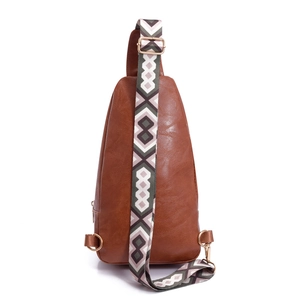 Detail view of brown pebbled PU leather sling bag with geometric woven shoulder strap